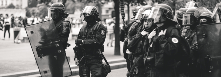 Police in riot gear line up